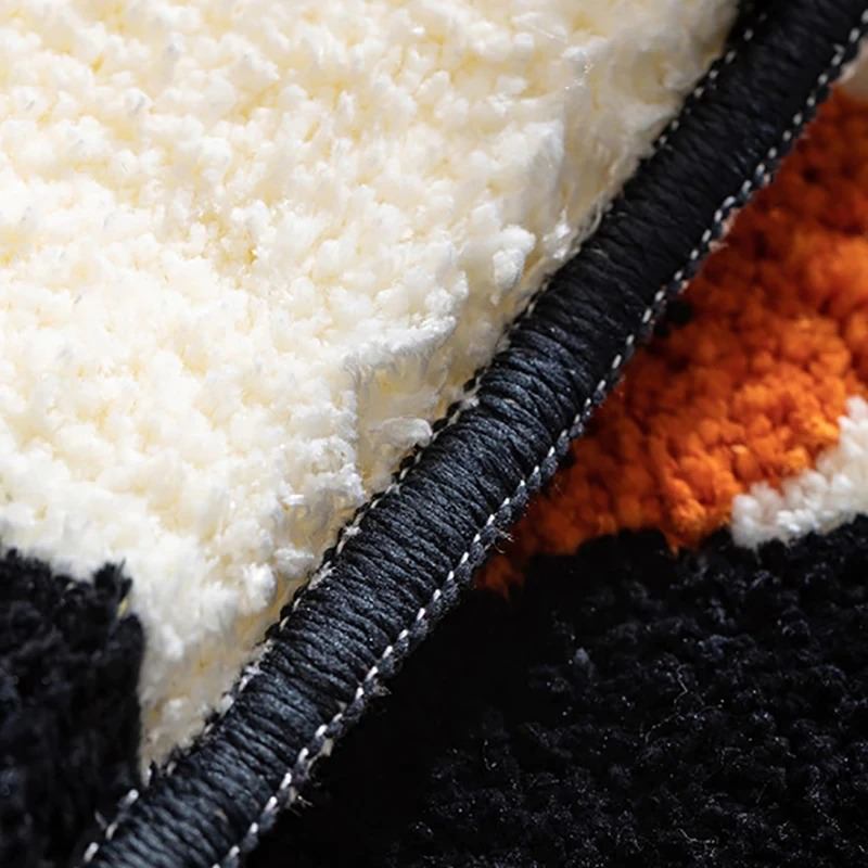 Dywanik dekoracyjny w kratkę z pomarańczowym kwiatowym akcentem